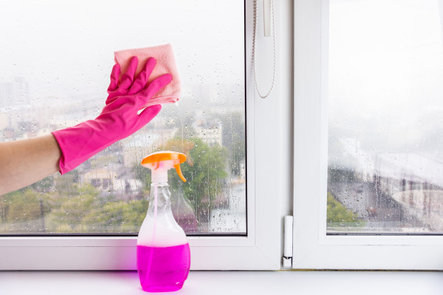 Cleaning window glasses with liquid cleaner.