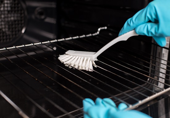 Cleaning an oven with a brush