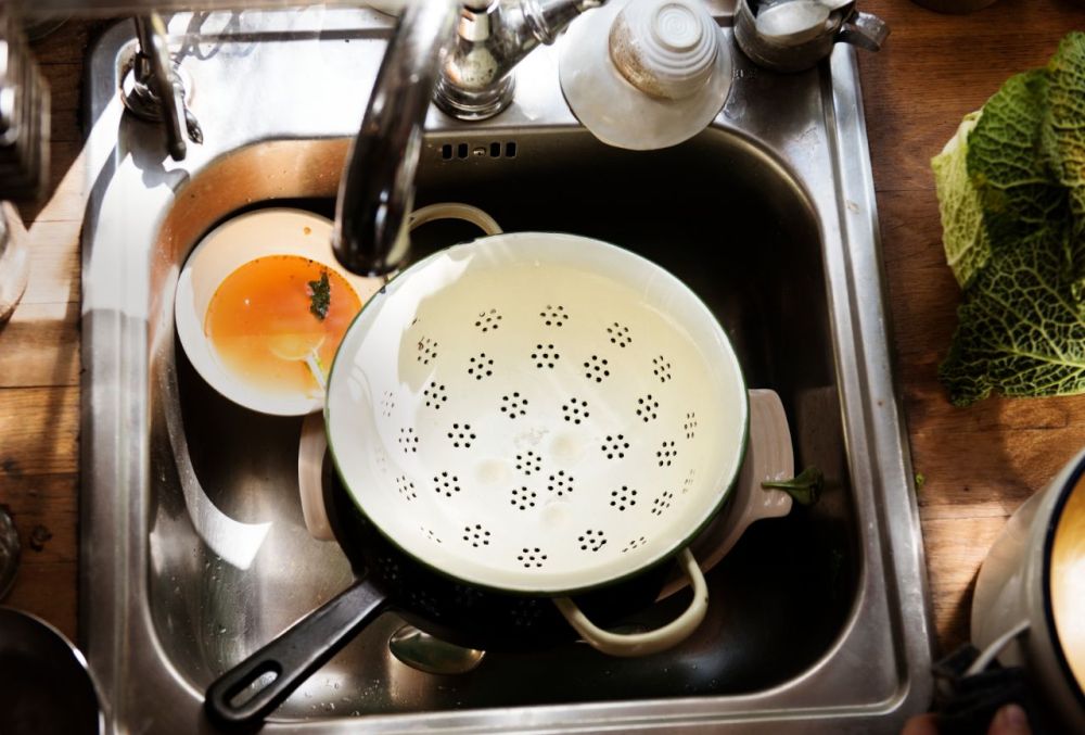 Cleaning pots and pans in the kitchen sink.