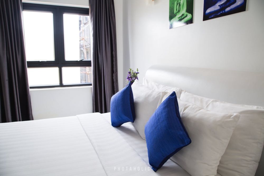 A well-lit room featuring a clean mattress adorned with crisp white sheets.