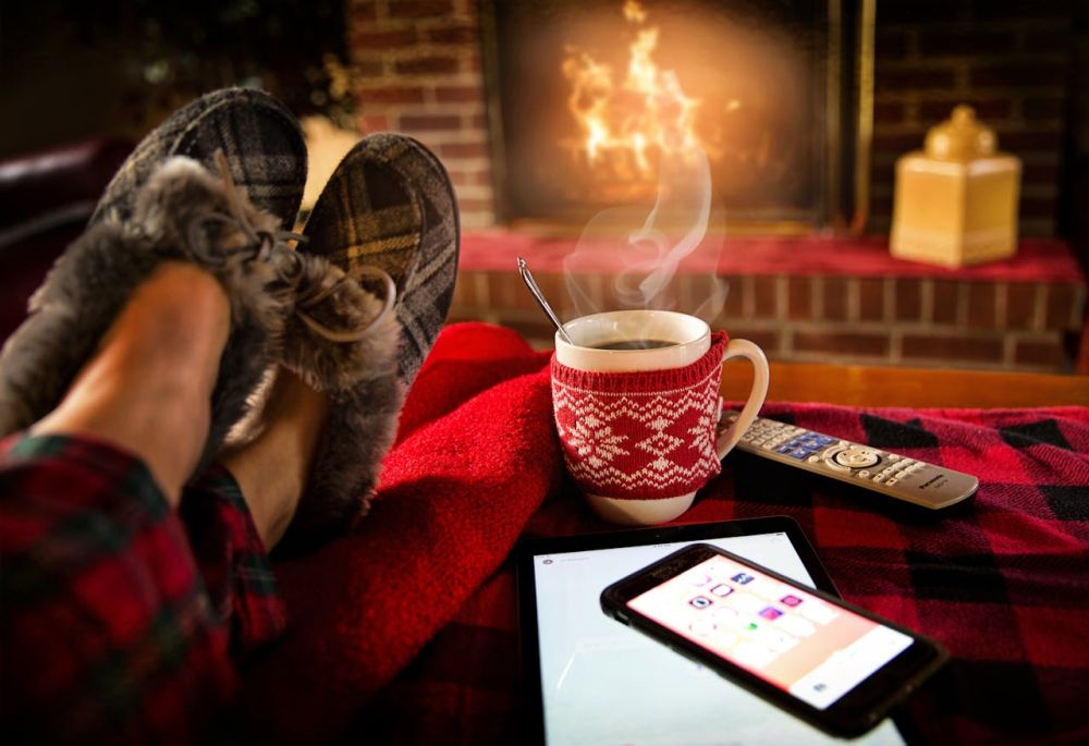 Relaxing under the blanket with a steaming cup of coffee.