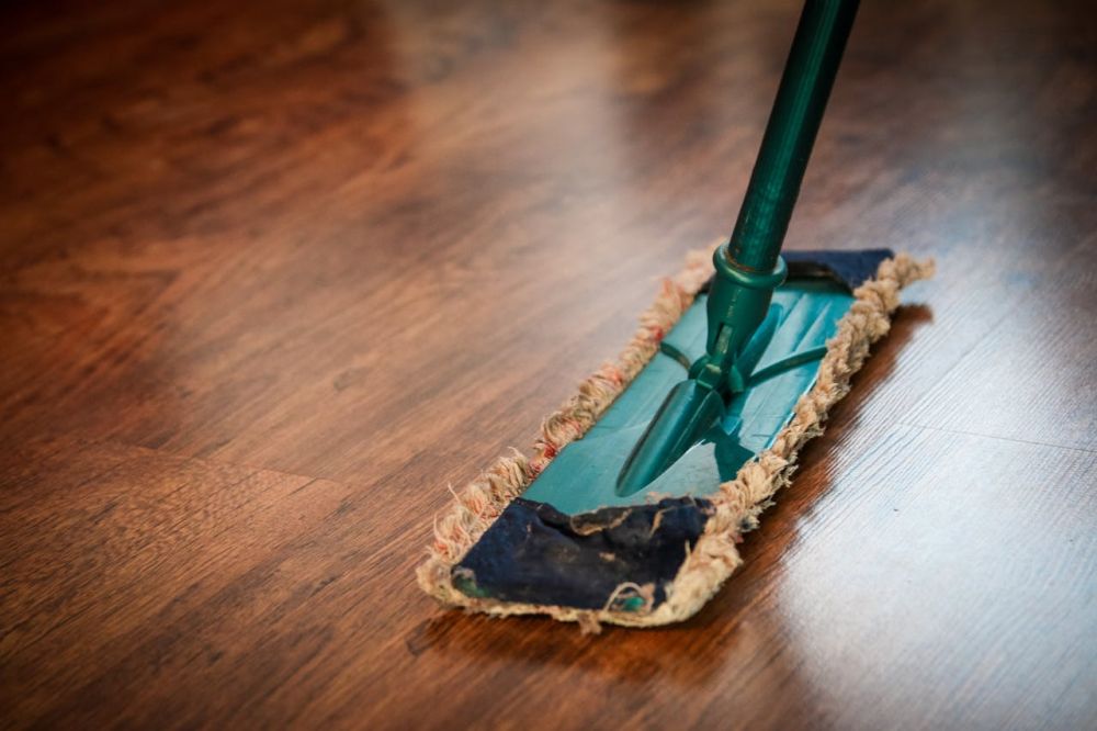 Mopping the floor with the firm handling of a tool.