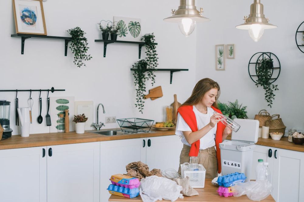 Woman holding items to recycle the kitchen.