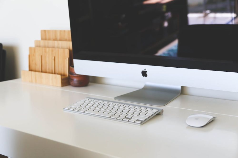 A clean desk and computer and keyboard.