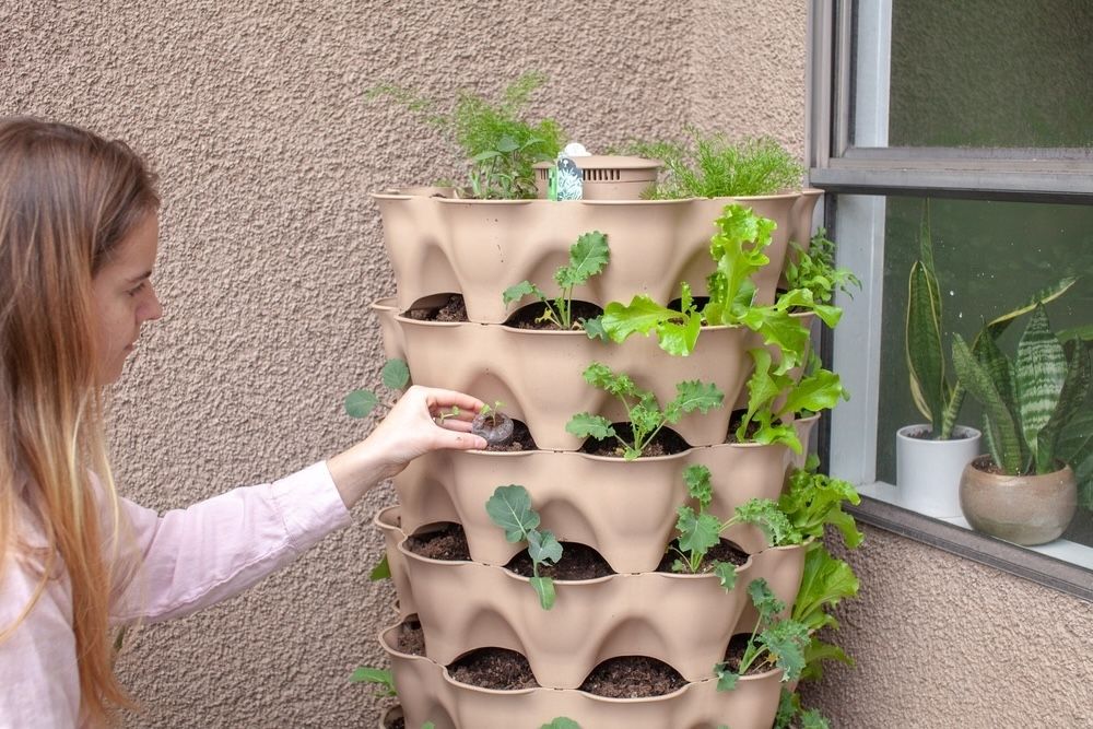 Tower gardens are ideal for maximizing space efficiency in small areas. This example demonstrates a vertical gardening system where multiple plants grow upward in a spiral pattern. Tower gardens are perfect for urban settings, allowing for diverse planting in a compact footprint.