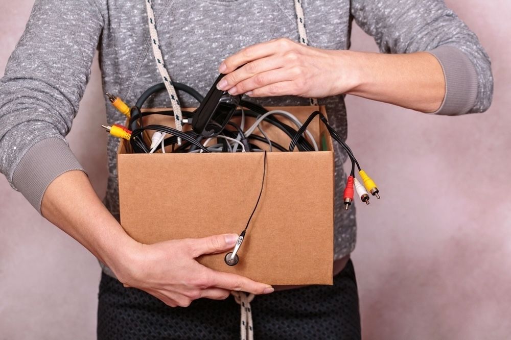 Organizing old cables and electronic accessories for future repurposing projects. Properly managing e-waste is a crucial step towards sustainability.