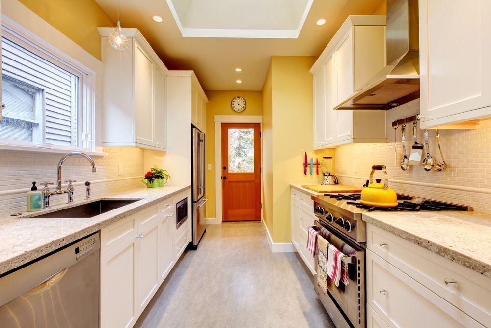 Vibrant colors like yellow can stimulate appetite and energy in the kitchen. Pairing yellow with white provides a clean and bright backdrop that enhances the space's overall liveliness.